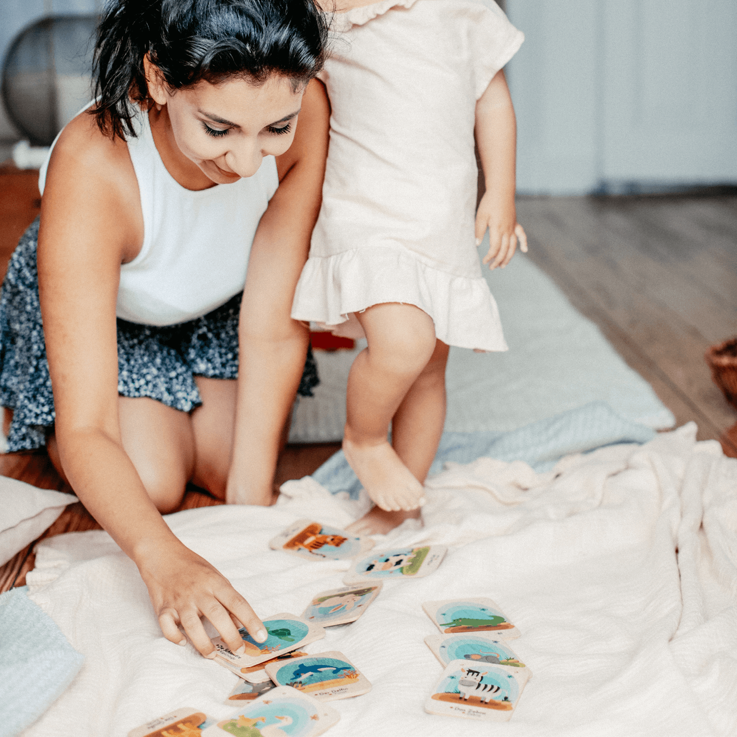 Mama und Kind spielen mit Tierkarten