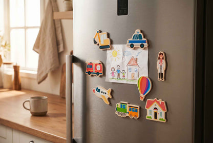Holzmagnete mit Fahrzeugen und Gebäuden dekorativ auf einem Kühlschrank und halten ein Blatt fest