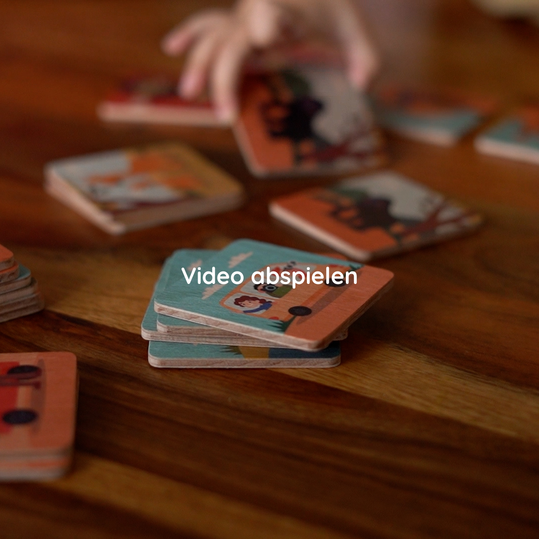Kind spielt mit Memospielkarten aus Holz